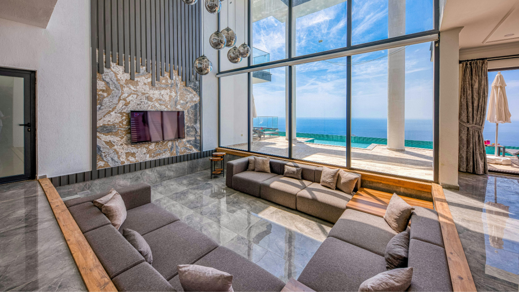 A staged luxury living room with large floor-to-ceiling windows showcasing a beautiful panoramic city or ocean view.