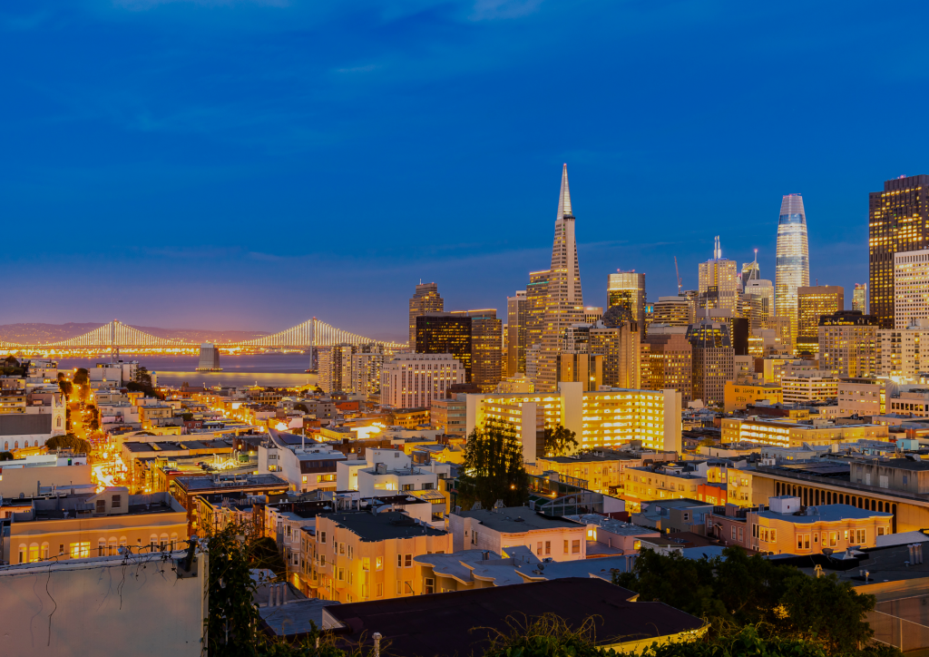 A modern luxury home exterior with floor-to-ceiling glass windows overlooking the San Francisco city skyline at twilight.