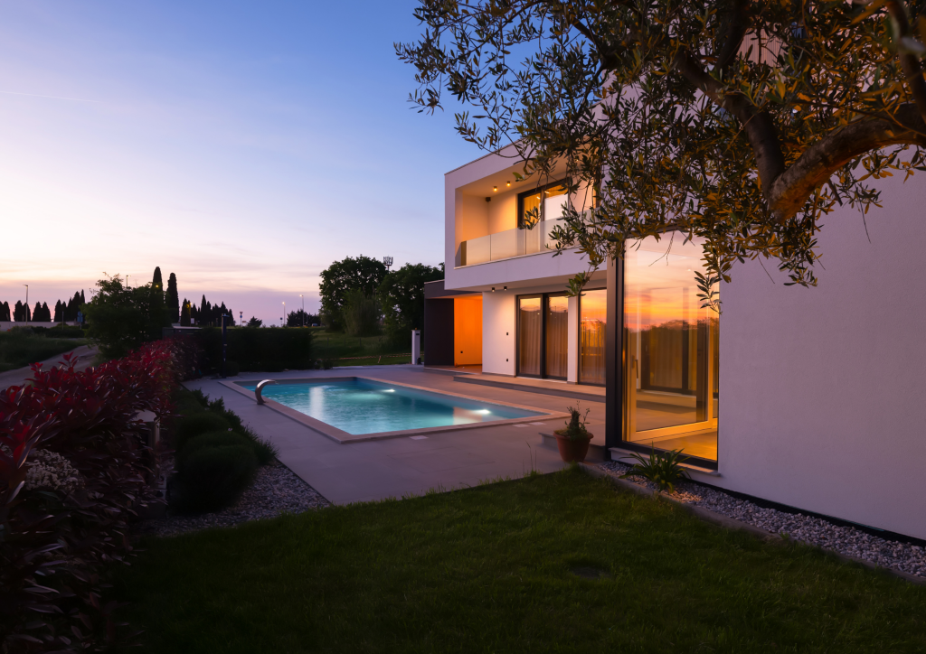 A wide-angle shot of a stunning modern luxury home at sunset, symbolizing stability and a safe haven in the Silicon Valley market.
